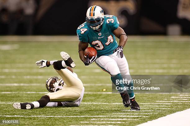 Ricky Williams of the Miami Dolphins avoids a tackle by Danny Gorrer of the New Orleans Saints at the Louisiana Superdome on September 3, 2009 in New...