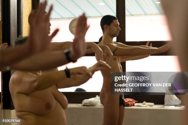 Graphic content / Nudists take part in a yoga lesson at the Roger Le Gall swimming pool in Paris on January 12, 2018. - Every week, some hours are...