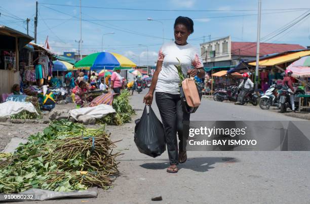 Papuan woman shops for vegetables at street market in Timika in Indonesia's easternmost Papua province, on January 25, 2018. Some 800 children have...