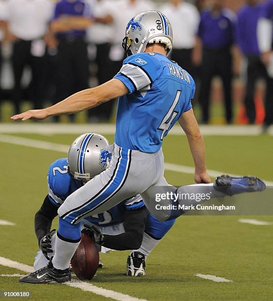 Jason Hanson of the Detroit Lions kicks a first quarter field goal while Nick Harris holds the ball against the Minnesota Vikings at Ford Field on...