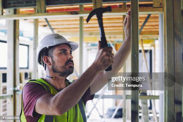 construction workers in australian in building site working and doing tasks. - hammer stock pictures, royalty-free photos & images