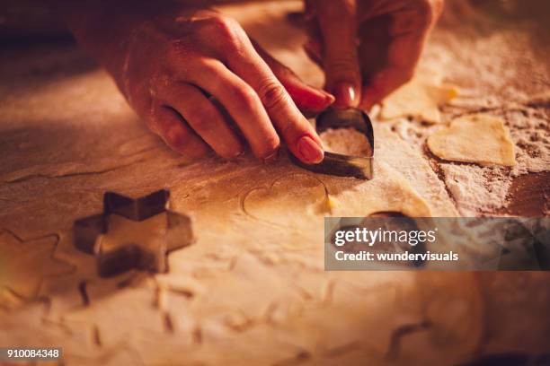 close-up of woman's hands making heart and star shaped cookies - cookie cutter stock pictures, royalty-free photos & images