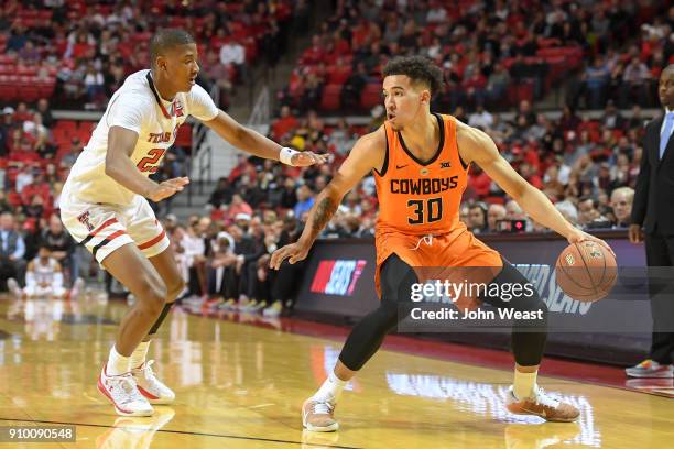 Jeffrey Carroll of the Oklahoma State Cowboys handles the ball against Jarrett Culver of the Texas Tech Red Raiders during the game on January 23,...