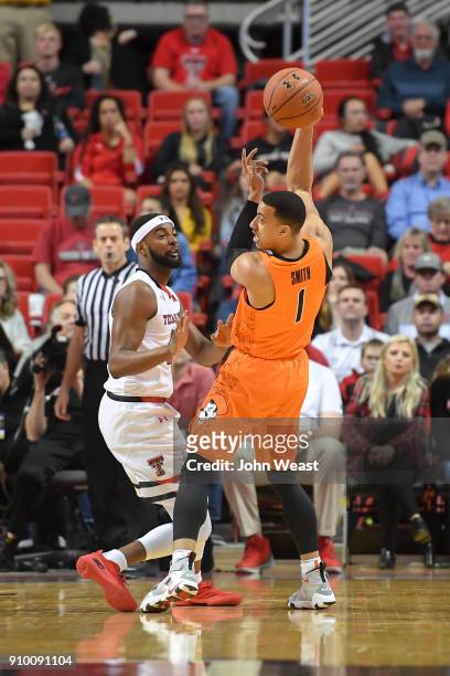 Kendall Smith of the Oklahoma State Cowboys passes the ball while defended by Niem Stevenson of the Texas Tech Red Raiders during the game on January...