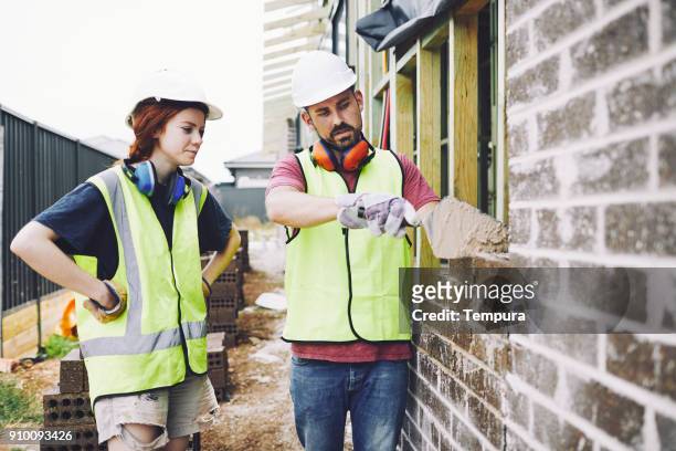 construction workers in australian in building site working and doing tasks. - builder apprenticeship stock pictures, royalty-free photos & images