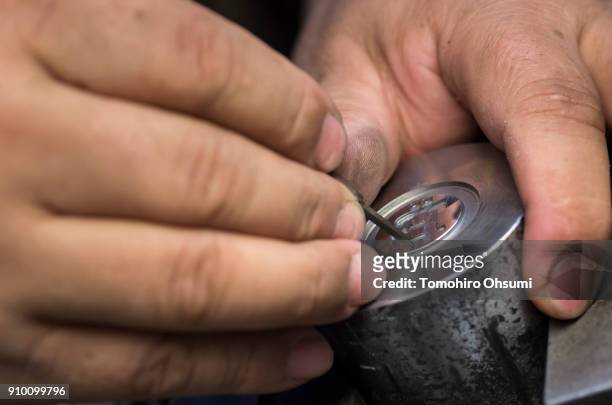 Sakamoto Metal President Kunio Sakamoto makes final touches to a metal mold for a bitcoin medal at the company's workshop on January 25, 2018 in...
