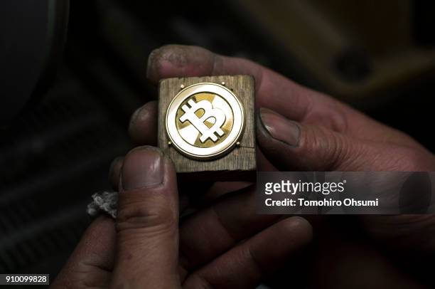 Worker polishes a brass Bitcoin medal produced by Sakamoto Metal at a workshop on January 25, 2018 in Tokyo, Japan. Sakamoto Metal, a custom medal,...