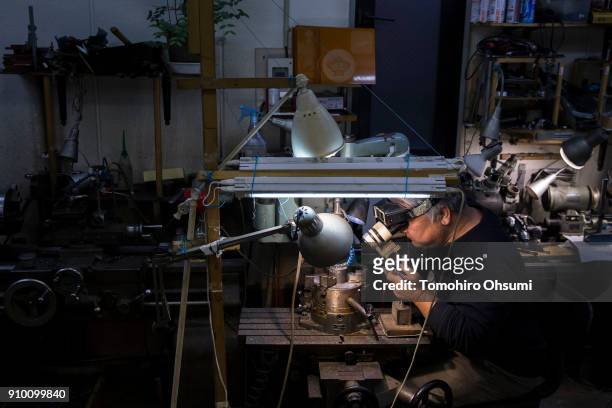 Sakamoto Metal President Kunio Sakamoto makes final touches to a metal mold for a bitcoin medal at the company's workshop on January 25, 2018 in...