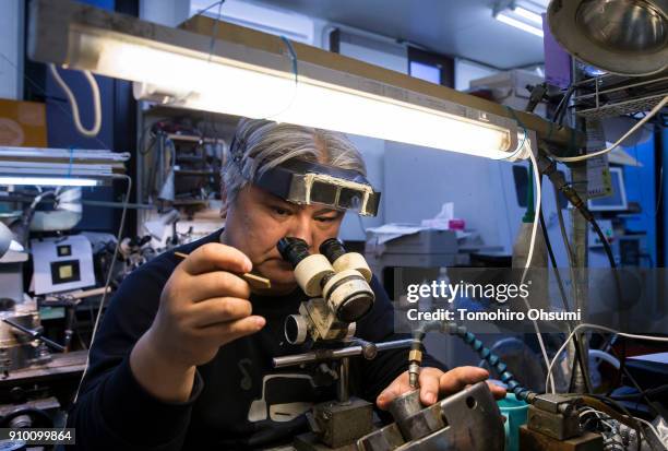 Sakamoto Metal President Kunio Sakamoto makes final touches to a metal mold for a bitcoin medal at the company's workshop on January 25, 2018 in...