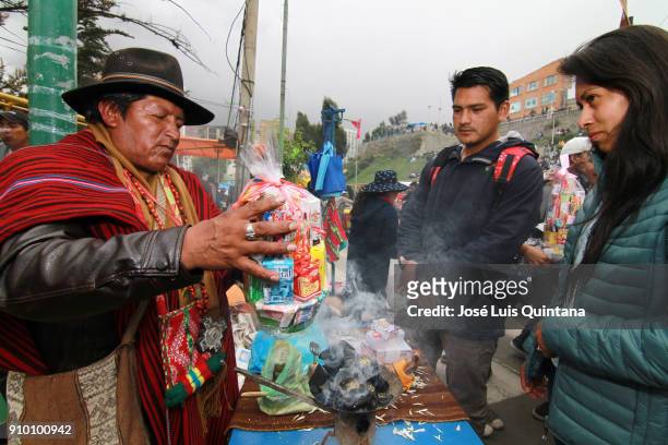 An Aymara priest, 'Yatiris', performs a blessing with alcohol and wine, known as "Ch'alla" during the Alasitas festival on January 24, 2018 in La...