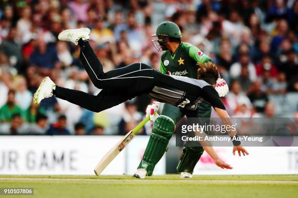Trent Boult of New Zealand goes after his own bowl as Sarfraz Ahmed of Pakistan looks on during the International Twenty20 match between New Zealand...