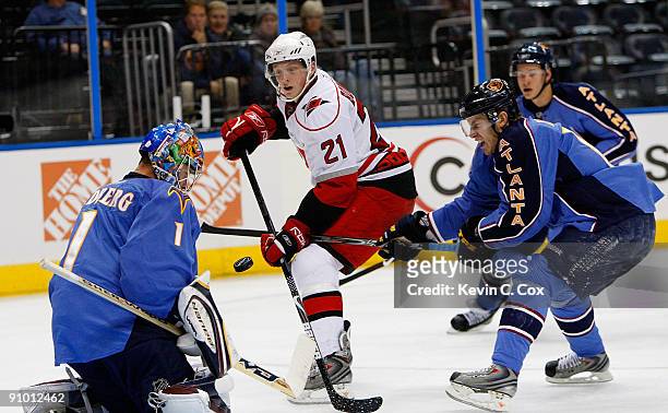 Bryan Little defends as goaltender Johan Hedberg of the Atlanta Thrashers saves a shot on goal by Drayson Bowman of the Carolina Hurricanes during a...