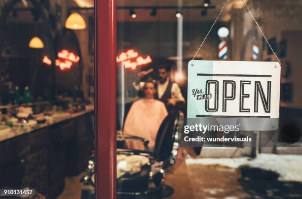 vetrina del barbiere con cartello aperto e barbiere che lavora al chiuso - barber shop foto e immagini stock