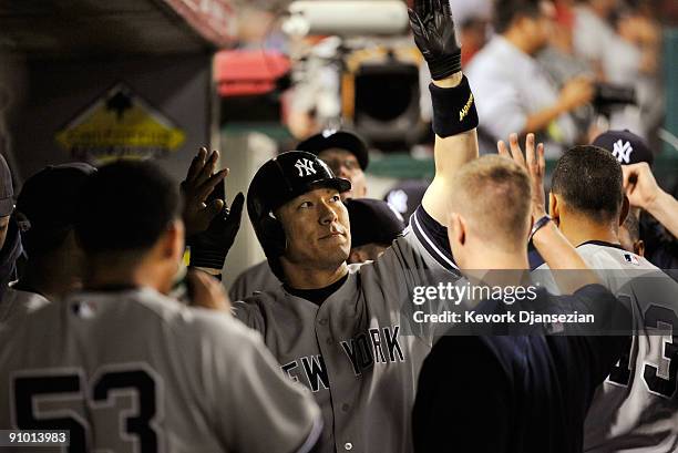 Hideki Matsui of the New York Yankees is congratulated by teammates after getting a pinch-hit solo home run in the eighth inning against the Los...