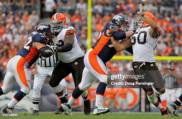 Defensive lineman Shaun Rogers and linebacker Eric Barton of the Cleveland Browns rush against center Casey Wiegmann and offensive tackle Chris Kuper...