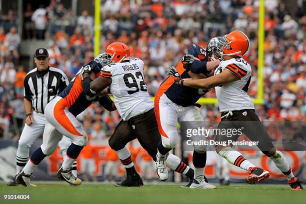 Defensive lineman Shaun Rogers and linebacker Eric Barton of the Cleveland Browns rush against center Casey Wiegmann and offensive tackle Chris Kuper...