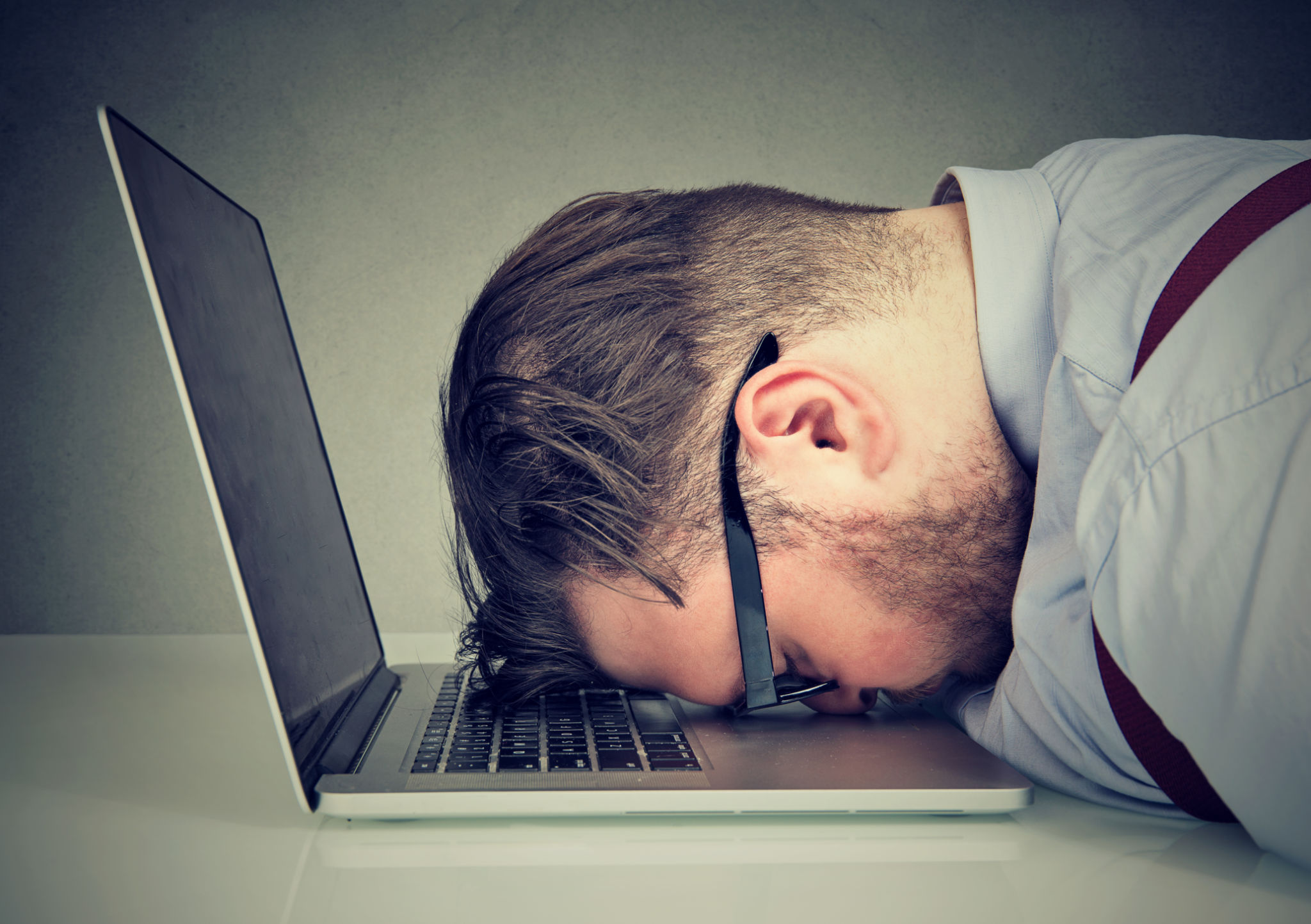 Overworked man lying on laptop Overworked man lying on laptop