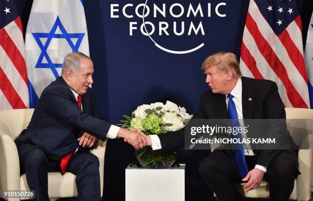 President Donald Trump shakes hands with Israel's Prime Minister Benjamin Netanyahu during a bilateral meeting on the sidelines of the World Economic...