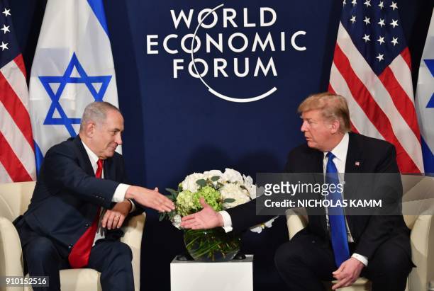 President Donald Trump shakes hands with Israel's Prime Minister Benjamin Netanyahu during a bilateral meeting on the sidelines of the World Economic...