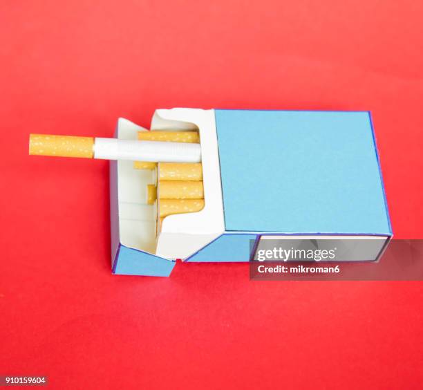 pack of cigarettes with one hanging over pack - zigarettenfilter stock-fotos und bilder