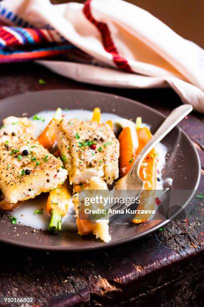 roasted white fish fillet with cream sauce and baby carrots on a plate, selective focus - peppercorn sauce stock pictures, royalty-free photos & images