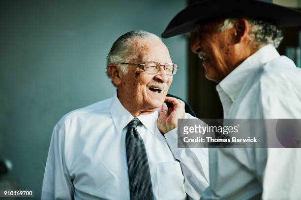 Laughing senior men greeting each other before outdoor family celebration