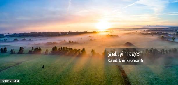 colorfull sunrise on foggy day over tipperary mountains and fields - maestosità foto e immagini stock