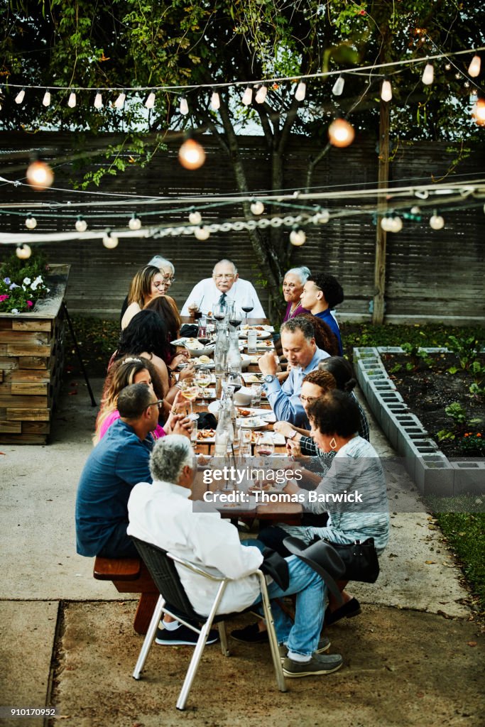 Extended family sharing celebration meal on outdoor patio