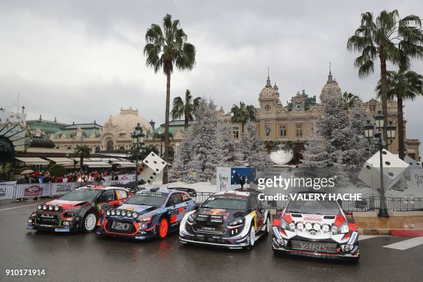 People look at cars of Citroen, Hyundai, M-Sport Ford and Toyota Racing's teams prior to the start of the season-opening Monte Carlo Rally on January...