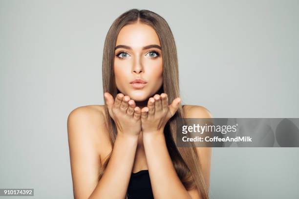 beautiful woman sending an air kiss - blowing kiss stock pictures, royalty-free photos & images
