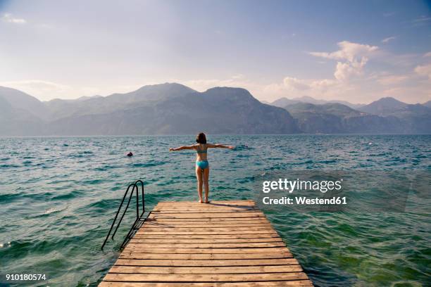 italy, brenzone, back view of girl standing on jetty - lago di garda 個照片及圖片檔