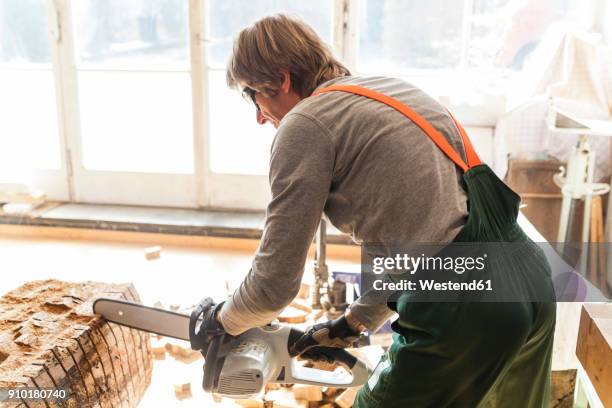 wood carver in workshopworking on wood for a sculpture with a chainsaw - dießen stock-fotos und bilder