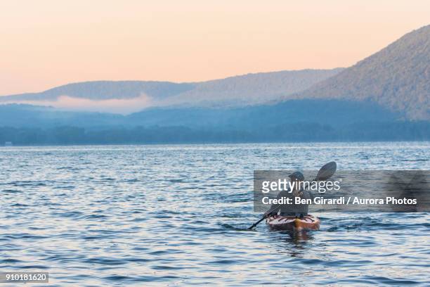 man kayaking at sunrise on skaneateles lake, skaneateles, new york state, usa - 斯加內特爾湖 個照片及圖片檔