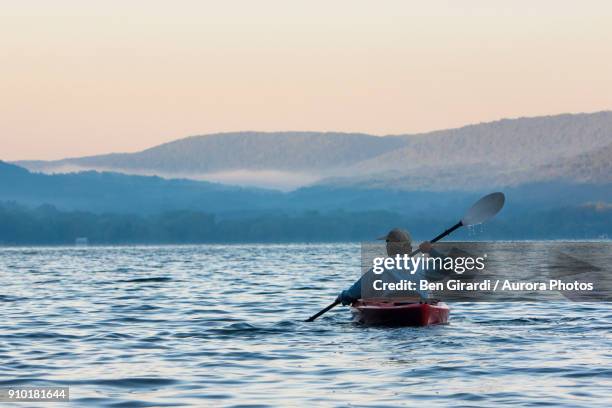 man kayaking at sunrise on skaneateles lake, skaneateles, new york state, usa - 斯加內特爾湖 個照片及圖片檔