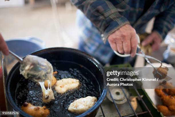 man preparing traditional oliebollen dutch doughnuts, langley, british columbia, canada - oliebollen stock pictures, royalty-free photos & images