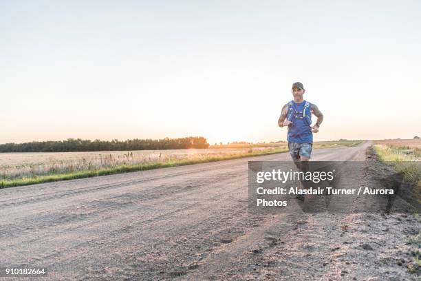 ultra runner training on rural roads of kansas outside wichita, usa - wichita stock pictures, royalty-free photos & images