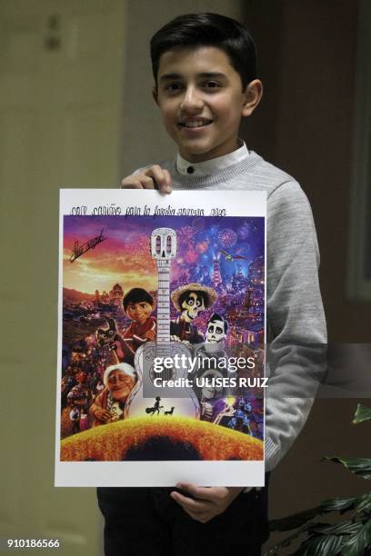 Mexican young singer Luis Angel Jaramillo poses with a poster of Disney-Pixar's film "Coco", before a concert, in the framework of the Fair of Villa...