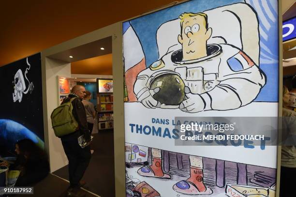 Visitor walks past an advert for Dans la combi de Thomas Pesquet comic during the 45th edition of the Angouleme International Comics Festival in...