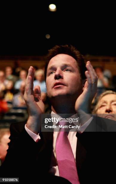 Leader of the party Nick Clegg applauds as Liberal Democrat party members and supporters listen to delegates speak during a policy motion at the...