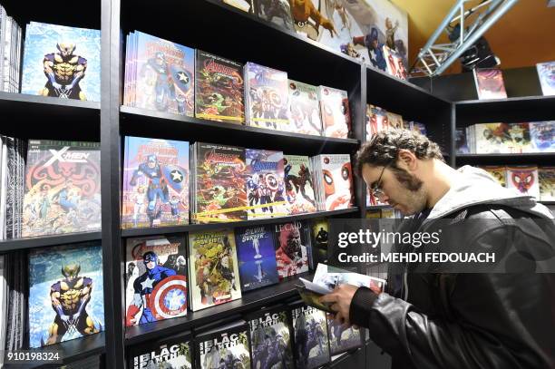 Visitor reads cartoons during the 45th edition of the Angouleme International Comics Festival in Angouleme, southwestern France, on January 25, 2018....