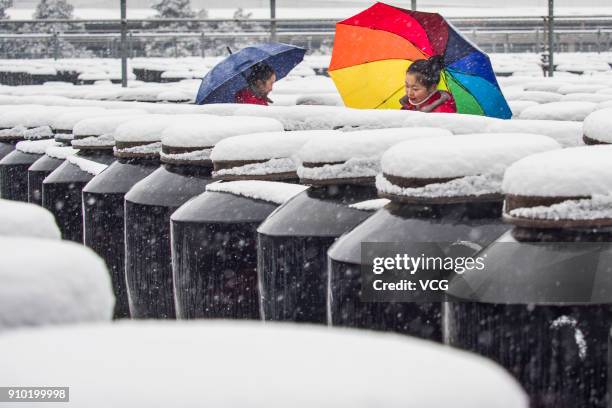 Employees inspect sealed soy sauce and vinegar jars during a snowfall at Hengshun Group on January 25, 2018 in Zhenjiang, China.