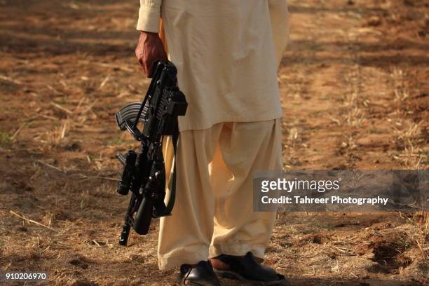 taliban carrying a gun - terrorism stock pictures, royalty-free photos & images