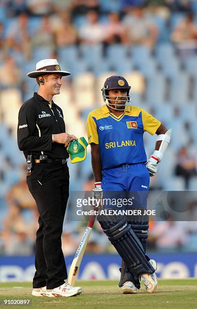 Sri Lanka cricket player Mahela Jayawardene and umpier Simon Taufea wait for the side screen to get fixed during The ICC Champions Trophy match...