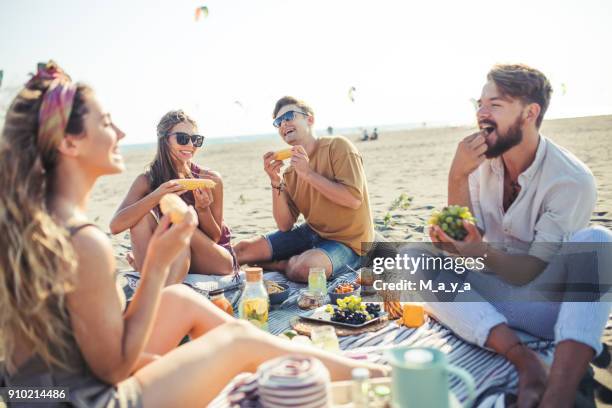 angenehmen strand picknick mit freunden - summer food stock-fotos und bilder