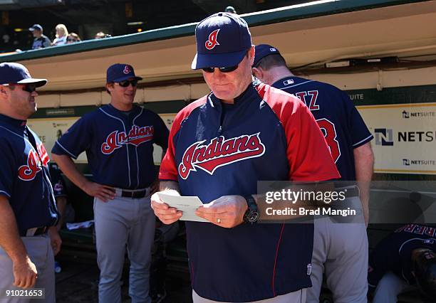 Manager Eric Wedge of the Cleveland Indians gets ready in the dugout before the game against the Oakland Athletics at the Oakland-Alameda County...