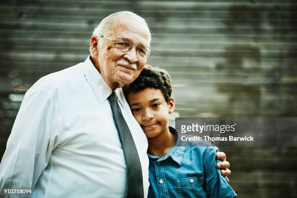 Smiling grandfather and grandson embracing after family dinner party