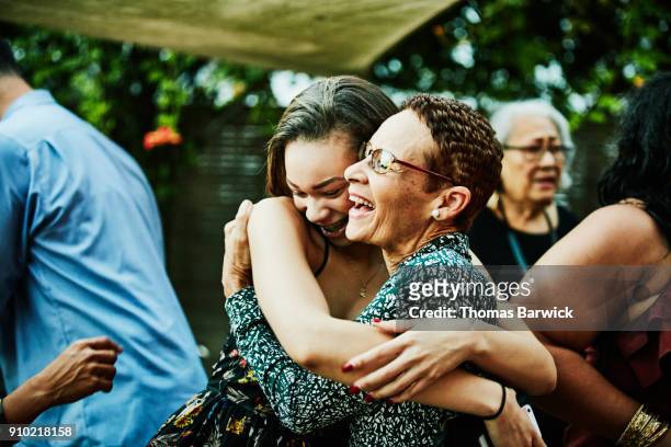 aunt embracing niece after outdoor family dinner party - teenager alter stock-fotos und bilder