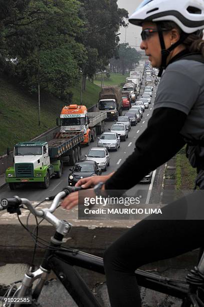 Cyclist gets ready to ride as a huge traffic jam line at 'Marginal Tiete' express highway is seen in the background, during World Car Free Day, in...