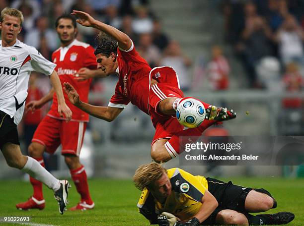 Mario Gomez of Muenchen falls after challenging goalkeeper Soeren Pirson during the DFB Cup second round match between FC Bayern Muenchen and...