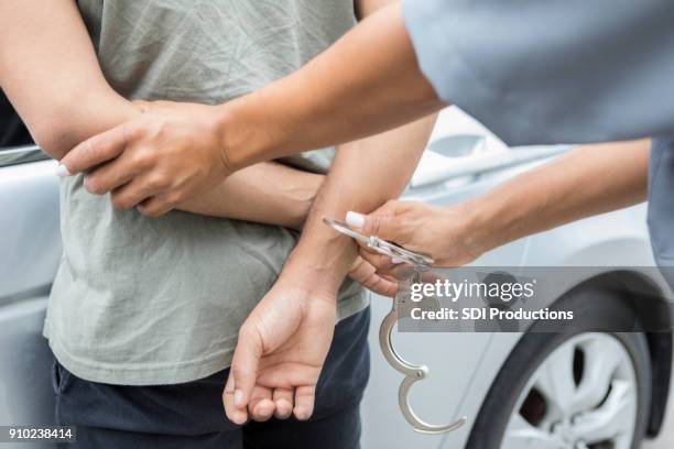 polizist verhaftungen junger mann - handschelle stock-fotos und bilder